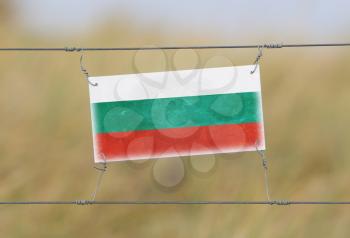 Border fence - Old plastic sign with a flag - Bulgaria