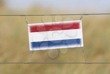 Border fence - Old plastic sign with a flag - Netherlands