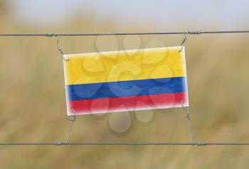 Border fence - Old plastic sign with a flag - Colombia