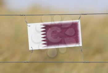 Border fence - Old plastic sign with a flag - Qatar
