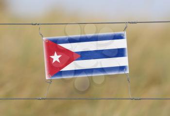 Border fence - Old plastic sign with a flag - Cuba