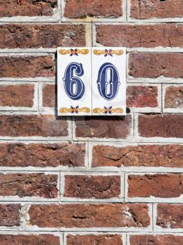 House number on a red brick wall in the Netherlands - 60