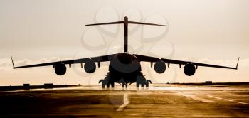 Large military cargo plane silhouette on an empty airstrip