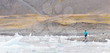 Woman walking over the beach at Jokulsarlon glacier lagoon in southern Iceland