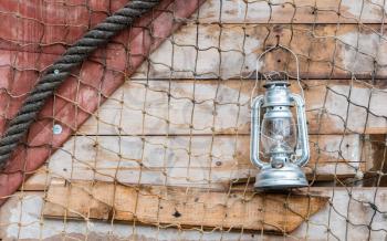 Old kerosene lamp hanging on the wall of a wooden house