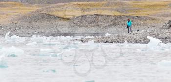 Woman walking over the beach at Jokulsarlon glacier lagoon in southern Iceland