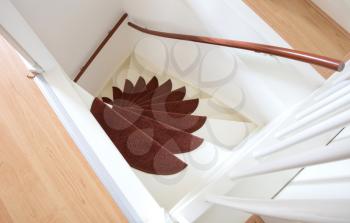 White wooden stairs with red mats, going upstairs