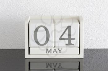 White block calendar present date 4 and month May on white wall background