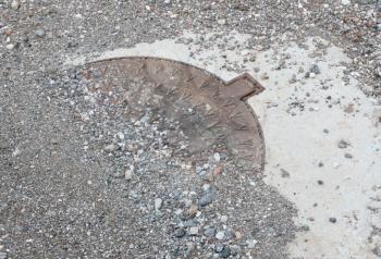 Circle steel manhole cover or metal sewer on a street in Greece