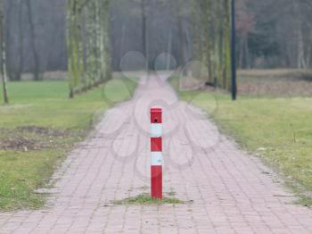 Close up, red and white traffic pole in the middle of the road