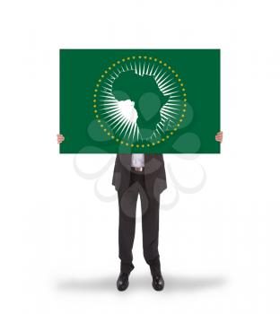 Businessman holding a big card, flag of the African Union, isolated on white