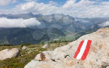 Walking path sign in Austria, flag painted on a rock