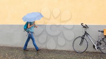Mysterious girl walking with umbrella on rainy day - Selective focus