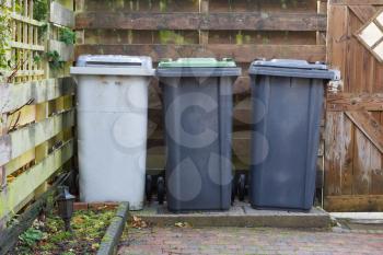 Three rolling trash cans in a dutch garden - Separating trash