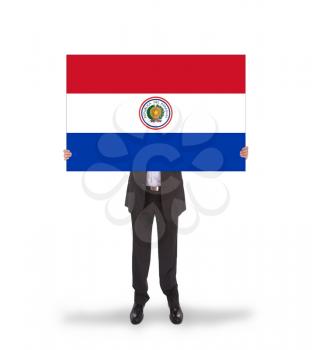 Businessman holding a big card, flag of Paraguay, isolated on white