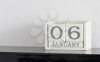 White block calendar present date 6 and month January on white wall background