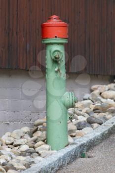 Green fire hydrant on a city sidewalk, Austria