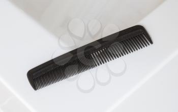 Used black comb in a bathroom - Selective focus