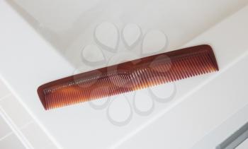 Used brown comb in a bathroom - Selective focus