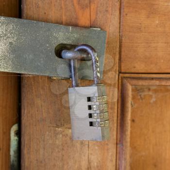 Steel digit combination lock on an old wooden door