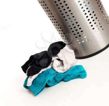 Dirty laundry in a metal basket, isolated on a white background