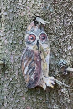 Education in the forest - wooden owl waiting to be spotted by children - Selective focus