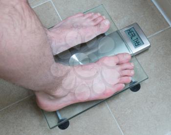 Closeup of man's feet on weight scale - Healthy