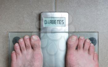 Closeup of man's feet on weight scale - Diabetes