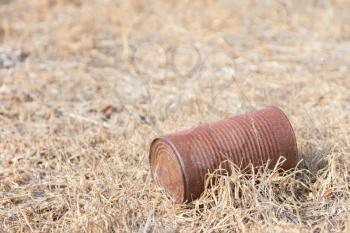 Garbage in nature - A rusty can on a field
