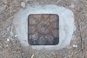Steel manhole cover or metal sewer on a street in Greece