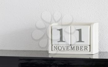White block calendar present date 11 and month November on white wall background