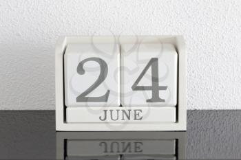 White block calendar present date 24 and month June on white wall background