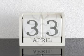 White block calendar present date 33 and month April on white wall background - Extra day