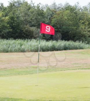 Red flag on a golf track, waving in the wind