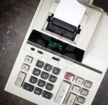 Old calculator with digital display showing a percentage - 60 percent