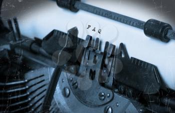 Close-up of an old typewriter with paper, perspective, selective focus, FAQ