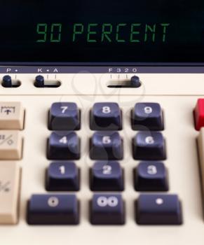 Old calculator with digital display showing a percentage - 90 percent