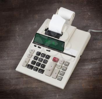 Old calculator with digital display showing a percentage - 90 percent