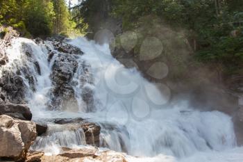 Waterfall in the forest, raging water in Switzerland