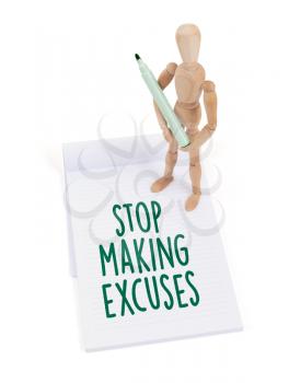 Wooden mannequin writing in a scrapbook - Stop making excuses