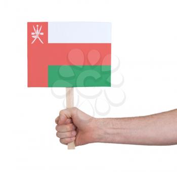 Hand holding small card, isolated on white - Flag of Oman