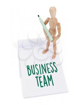 Wooden mannequin writing in a scrapbook - Business team