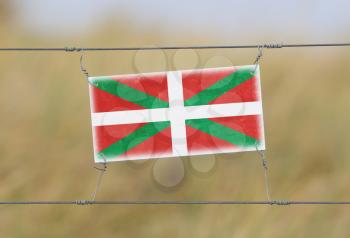 Border fence - Old plastic sign with a flag - Basque Country