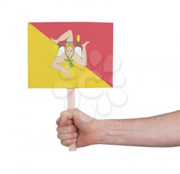 Hand holding small card, isolated on white - Flag of Sicily