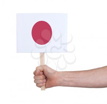 Hand holding small card, isolated on white - Flag of Japan