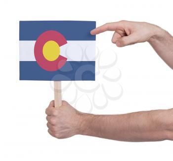 Hand holding small card, isolated on white - Flag of Colorado