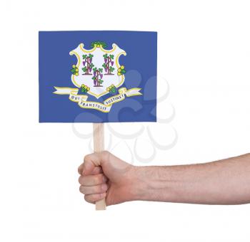 Hand holding small card, isolated on white - Flag of Connecticut