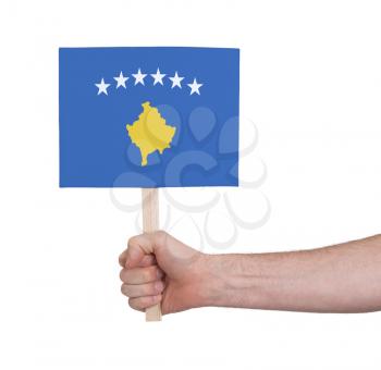 Hand holding small card, isolated on white - Flag of Kosovo