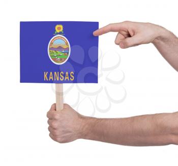 Hand holding small card, isolated on white - Flag of Kansas