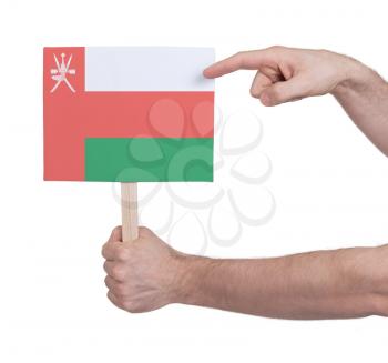 Hand holding small card, isolated on white - Flag of Oman